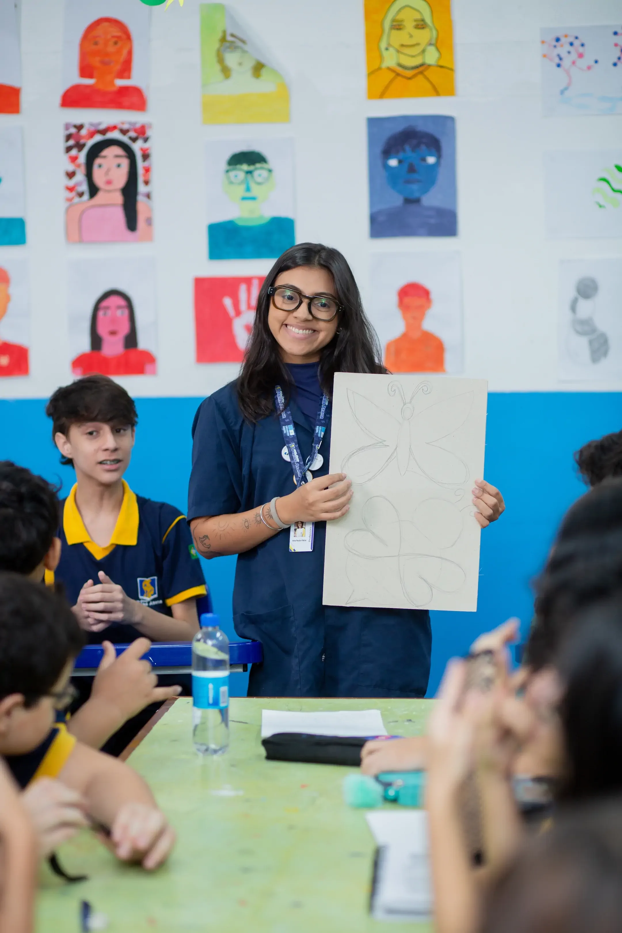 Professora do Palas Atena apresentando um trabalho de arte à turma