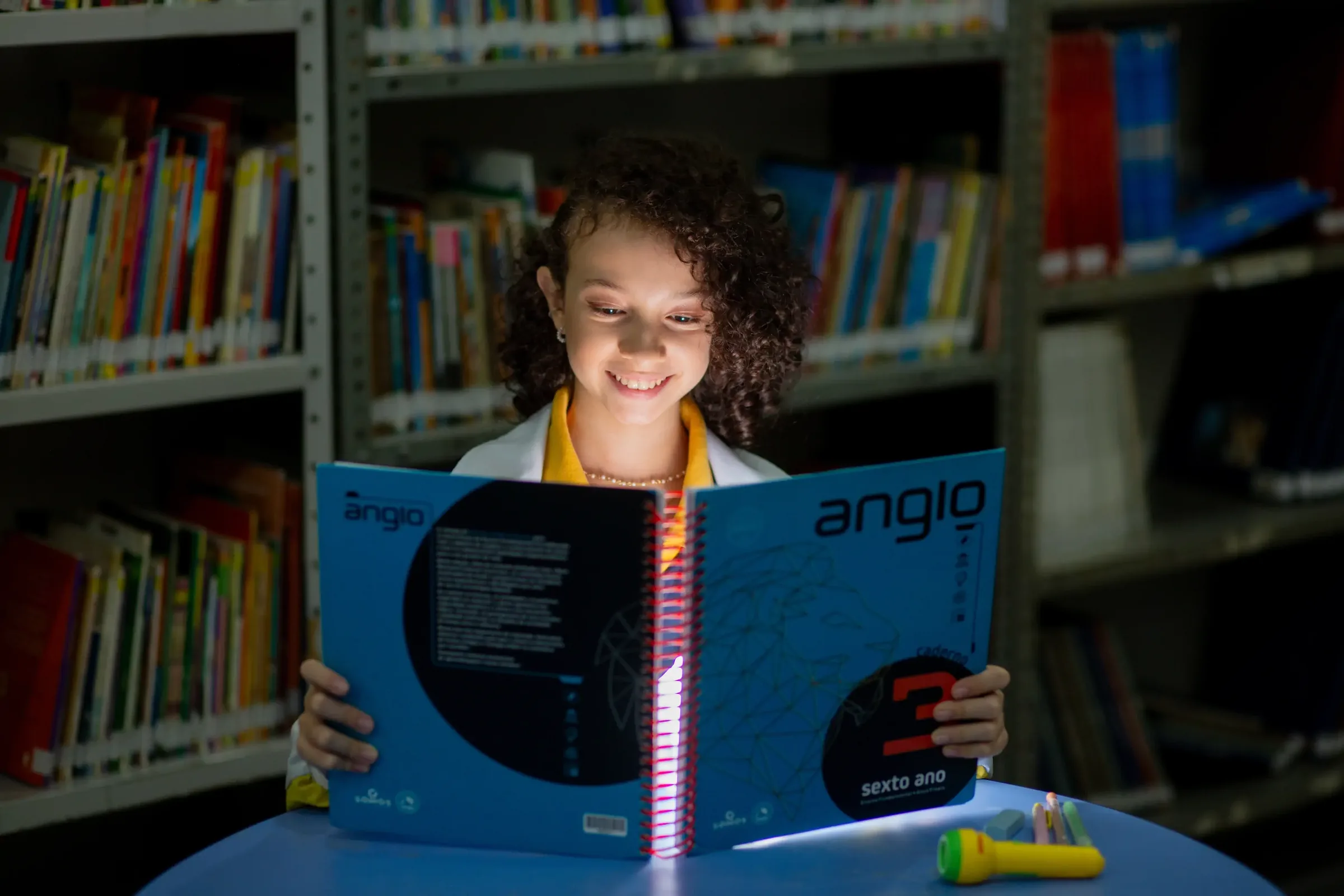 Aluna do Palas Atena lendo apostila na biblioteca