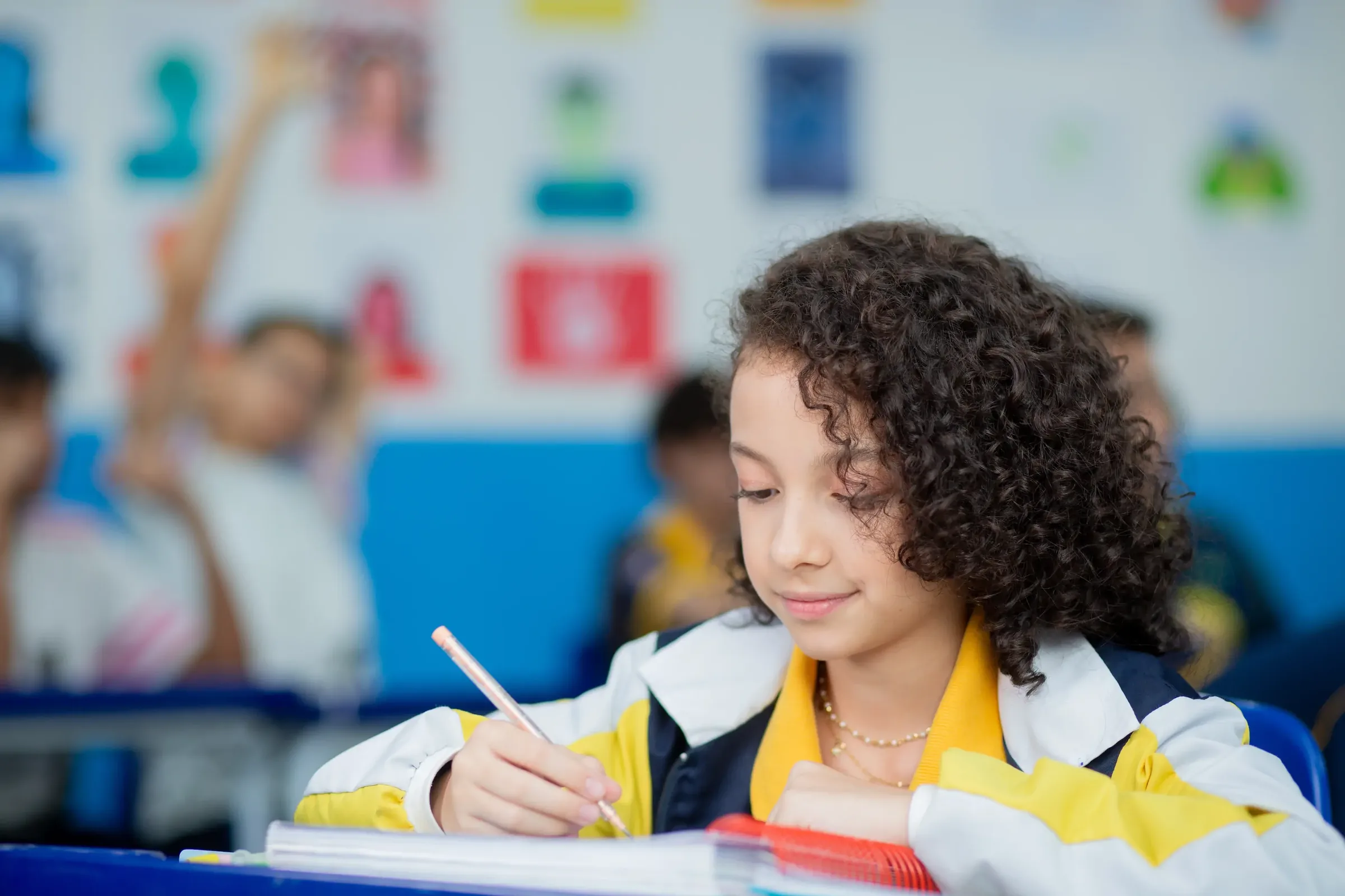 Aluna do Palas Atena escrevendo no caderno em sala de aula