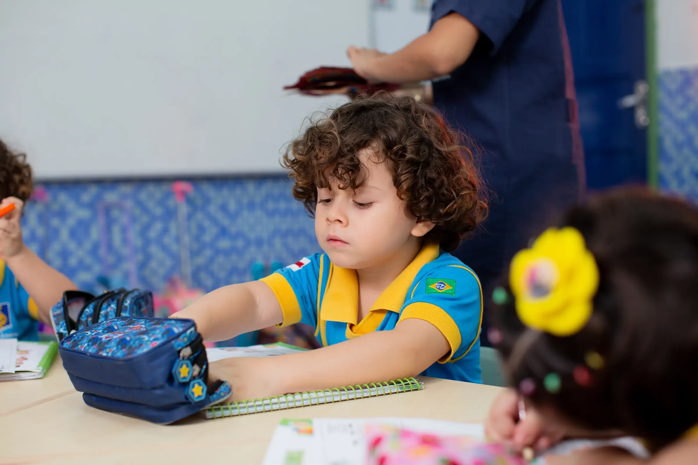 Aluna da educação infantil do Palas Atena na mesa de atividades