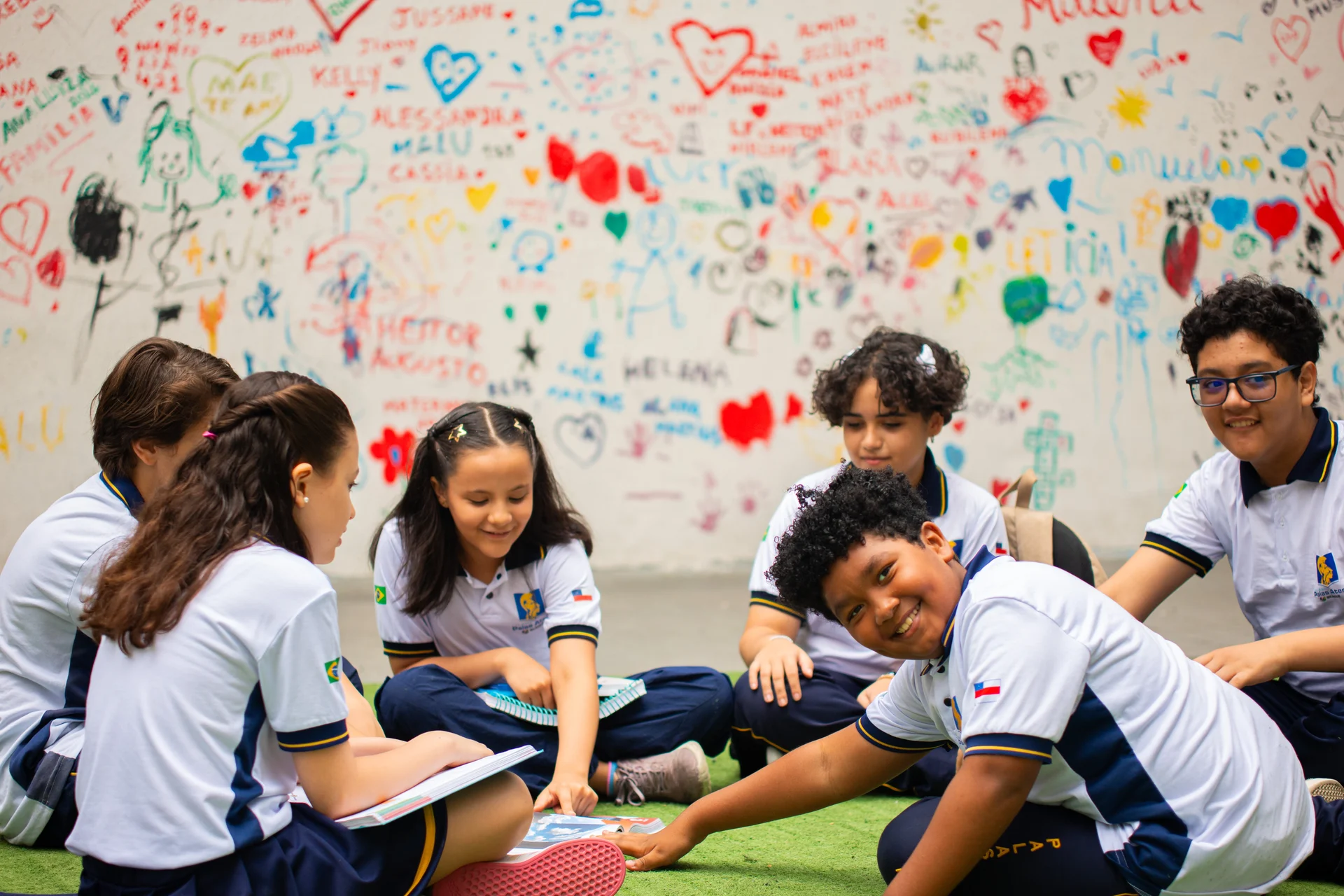 Grupo de estudantes do Ensino Médio reunidos em círculo estudando no pátio do colégio