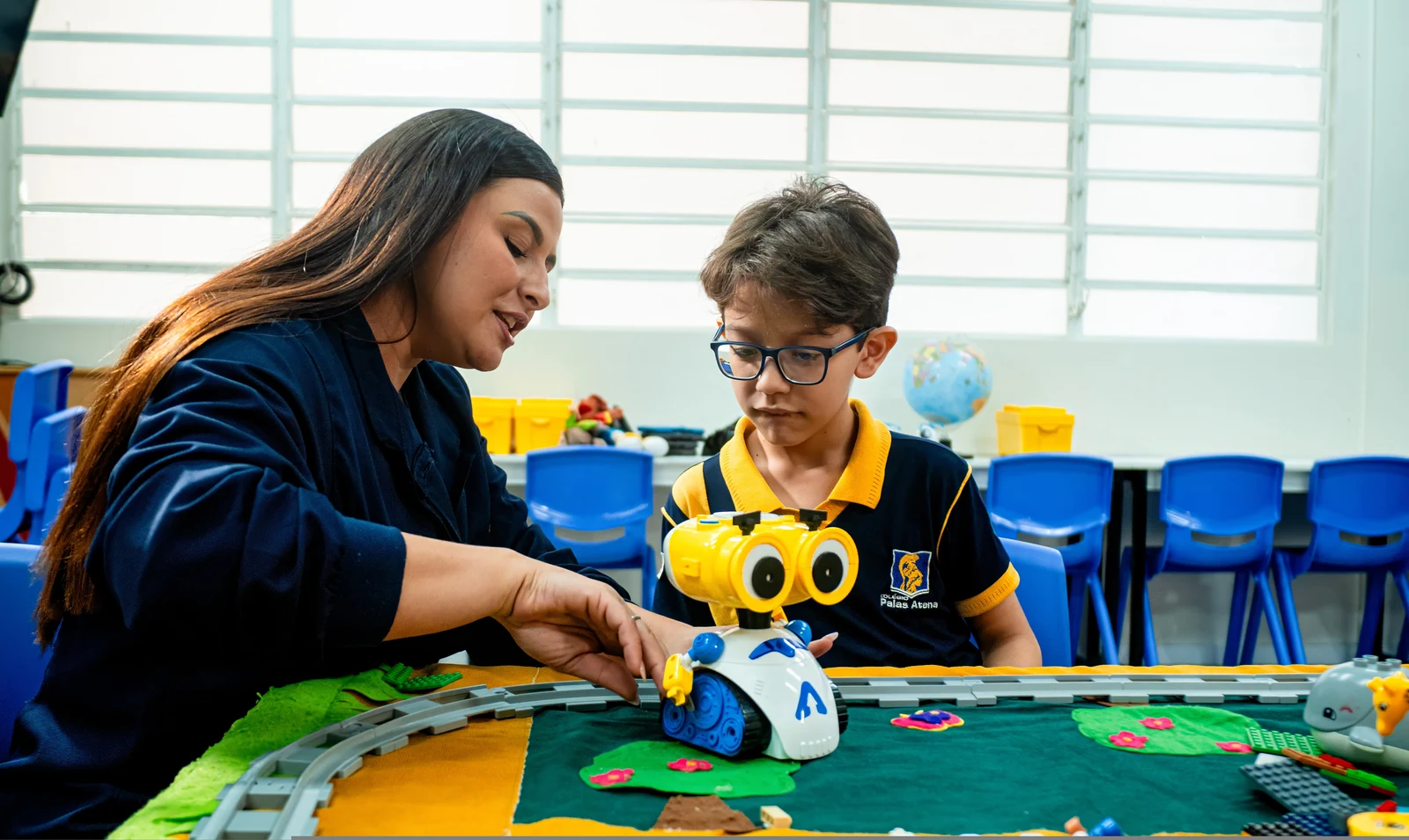 Alunas e alunos do Palas Atena desenvolvendo projeto de robótica na sala maker com a professora